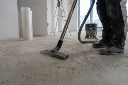 Bauschmutz wird mit einem Industriesauger vom Estrich aufgenommen